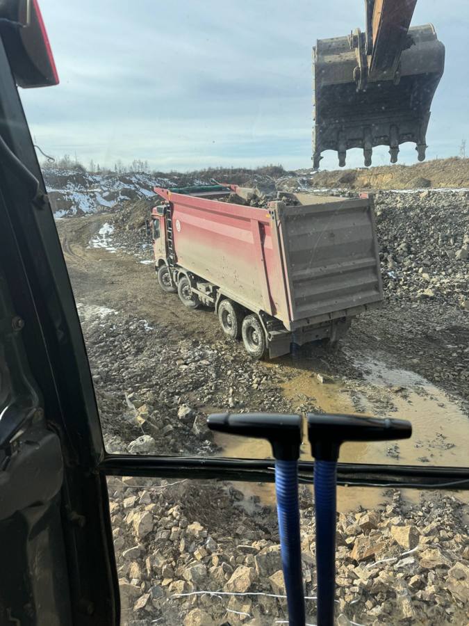Загрузка самосвала ковшом экскаватора